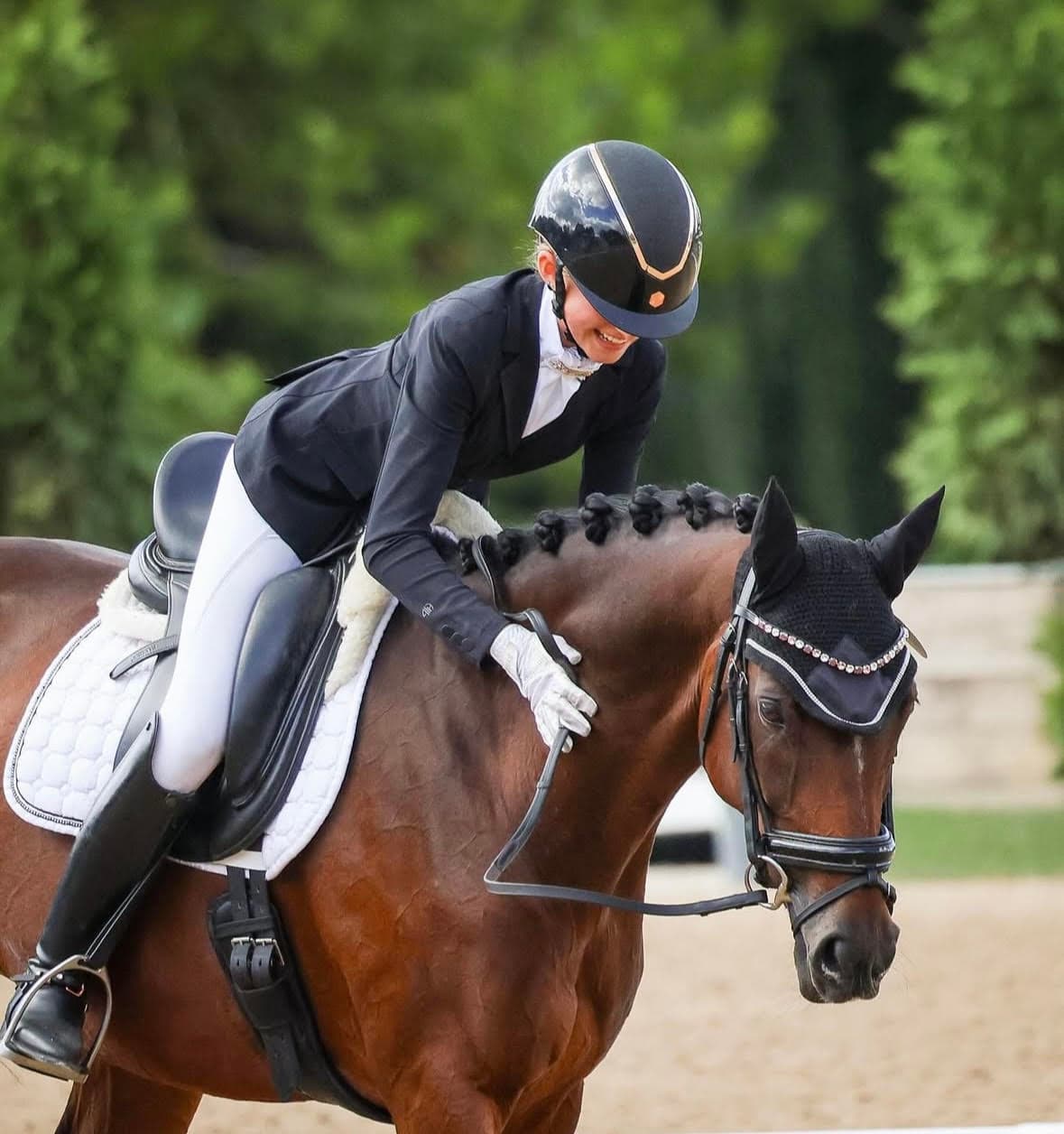 Young rider with her dressage horse at a competition
